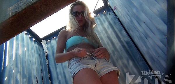  Hidden camera in a beach cabin.Tanned blonde in denim shorts .